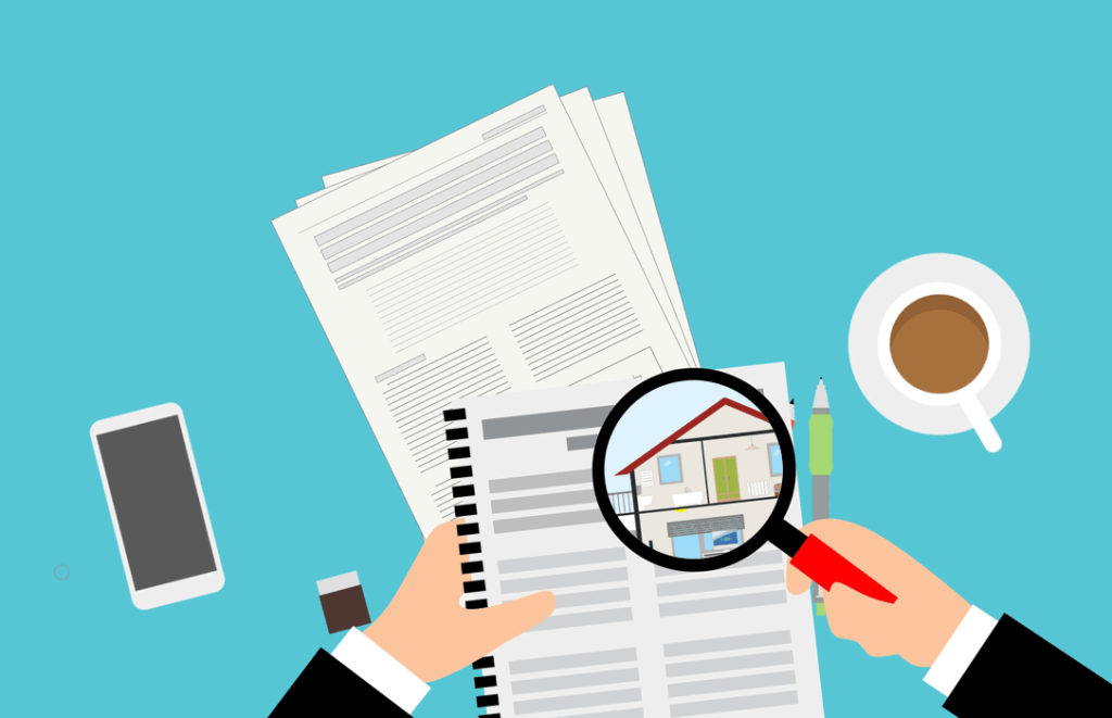 View from above of blue table top with papers, documents a cup of coffee and pens and phone. Hands hold a magnifying glass and a bound document and a house cross-section interior is visible in the magnifier lens.