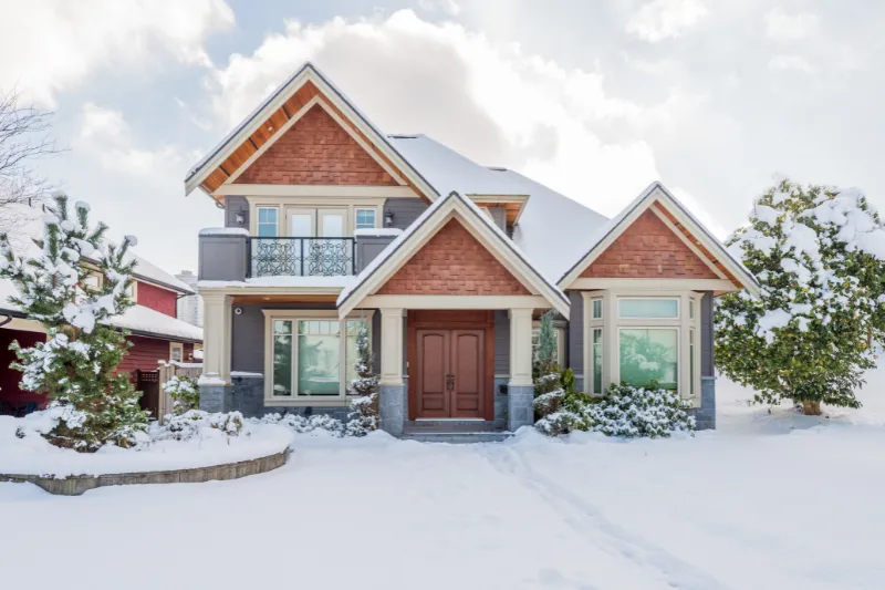 Photo of a gorgeous house covered in snow for blog article about winter home buying